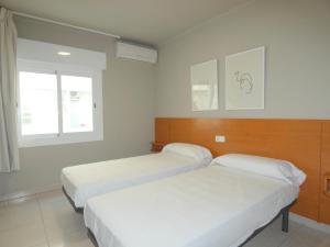 a room with two beds and a window at Rentalmar Family Acantilados in Salou