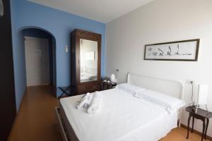 a bedroom with a white bed and a blue wall at Mami Sabaudia Hotel in Sabaudia