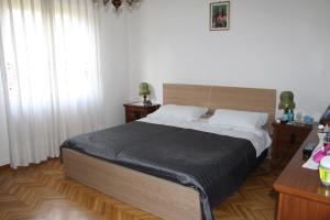 a bedroom with a bed and two tables and a window at Villa Raggio della Valle in Bagno di Romagna