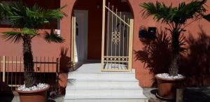 a front door of a pink house with palm trees at Apartments Danilo Kažanegra in Sveti Stefan