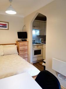 małą sypialnię z łóżkiem i kuchnią w obiekcie 'Mysty' Studio style Winter deal on 3 nights or more Nov to Mar w mieście Windermere