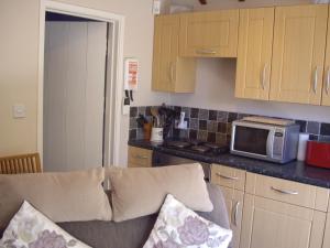 a kitchen with a couch and a microwave at Wishing Well Garden Apartment in Wilmington