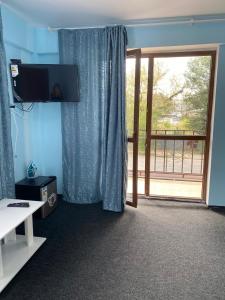 a room with a television and a sliding glass door at Пана in Almaty