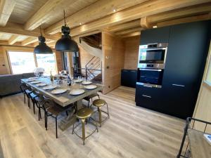 eine Küche und ein Esszimmer mit einem Tisch und Stühlen in der Unterkunft LAKE LOUISE Chalet mitoyen proche pistes avec vue panoramique in La Toussuire