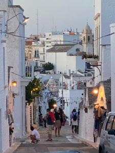 a group of people walking down a street with buildings at Trullo Eliana in Alberobello +25 photos