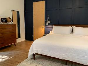 1 dormitorio con 1 cama blanca grande y vestidor en NormalBnB - 2 Blocks From Restaurants, Bars, Hospital en Athens