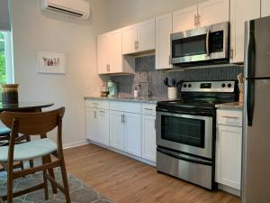 a kitchen with white cabinets and a stove and microwave at NormalBnB - 2 Blocks From Restaurants, Bars, Hospital in Athens