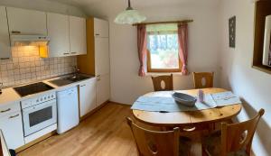 a kitchen with a wooden table and a table and chairs at Haus Polleruhs in Aflenz Kurort