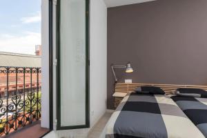 1 dormitorio con 2 camas y balcón en ºº Atocha Station Studio ºº, en Madrid