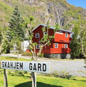 a sign in front of a house with a red house at Skahjem Gard in Aurland