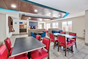 un comedor con mesas y sillas rojas en Holiday Inn Express and Suites Three Rivers, an IHG Hotel, en Three Rivers