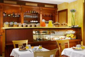 un ristorante con due tavoli e un buffet con cibo di Hotel Tuscolana a Roma