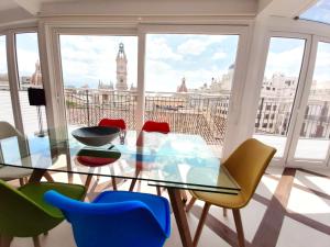 einen Esstisch aus Glas mit Stühlen und Stadtblick in der Unterkunft Valencia Town Hall Dream in Valencia