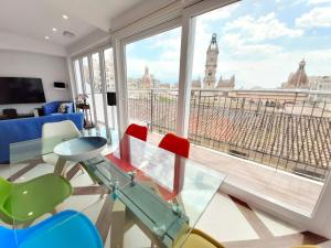 ein Zimmer mit einem Glastisch und Stühlen sowie einem großen Fenster in der Unterkunft Valencia Town Hall Dream in Valencia