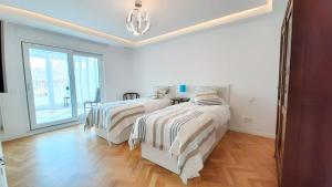 a bedroom with two beds and a large window at Valencia Town Hall Dream in Valencia