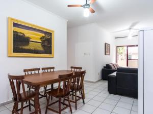 a living room with a table and chairs and a couch at Apartamento espaçoso com ar condicionado e Wi-fi, a 100 metros da praia - Edifício Estoril in Ubatuba