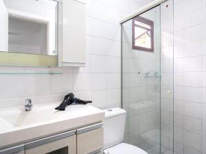 a bathroom with a toilet and a sink and a shower at Apartamento espaçoso com ar condicionado e Wi-fi, a 100 metros da praia - Edifício Estoril in Ubatuba +14 photos