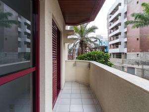 a balcony of a building with a red door at Apartamento espaçoso com ar condicionado e Wi-fi, a 100 metros da praia - Edifício Estoril in Ubatuba