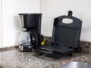 a coffee maker sitting on a kitchen counter at Apartamento espaçoso com ar condicionado e Wi-fi, a 100 metros da praia - Edifício Estoril in Ubatuba