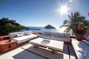 a living room with a couch and a table at Casa Azul & Casa Carioca in Careyes in Careyes