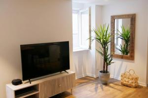 a living room with a flat screen tv on a cabinet at LE TROPICOCO - hyper centre d'Auray - in Auray