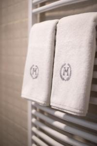 a group of towels on a rack in a bathroom at Magellan Family Lux Apartments Novi Sad in Novi Sad