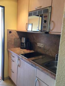 a small kitchen with a sink and a microwave at Südstrandwohnung in Fehmarn