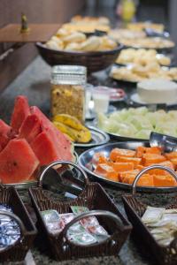 une table avec des bols de fruits et des paniers de nourriture dans l'établissement Hotel Marina Torrano, à Trindade