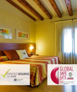 una habitación de hotel con una cama y un letrero para una zona segura a nivel mundial en Sercotel Palacio de Tudemir, en Orihuela
