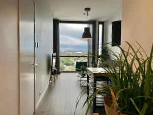 a hallway with a table and plants and a large window at Orange Apartments Tower & Free Parking in Tallinn