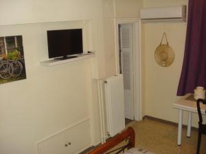 Pokój z telewizorem na ścianie z grzejnikiem w obiekcie Apartment city center w mieście Patras