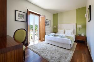 a bedroom with a bed and a sliding glass door at Hotel de Charme Casa da Amieira in Amiães de Cima
