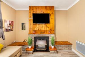 a living room with a fireplace and a flat screen tv at Crawford House in Newcastle upon Tyne