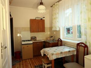 a kitchen with wooden cabinets and a table in it at Stokrotka in Susiec