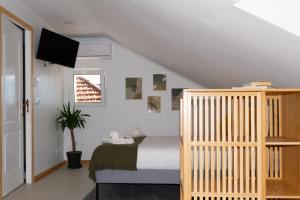 a bedroom with a bed and a crib at Seixal Bay Apartments in Arrentela