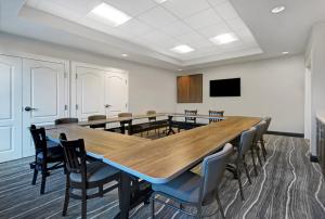 une salle de conférence avec une grande table et des chaises en bois dans l'établissement Staybridge Suites - Sterling Heights -Detroit Area, an IHG Hotel, à Sterling Heights