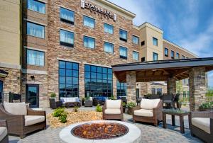 une terrasse avec un foyer extérieur en face d'un bâtiment dans l'établissement Staybridge Suites - Sterling Heights -Detroit Area, an IHG Hotel, à Sterling Heights