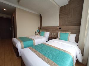 2 łóżka w pokoju hotelowym obok siebie w obiekcie Hotel Diamond Lima w mieście Lima