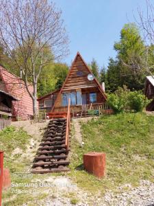 une cabane en rondins avec des escaliers menant à une maison dans l'établissement Noclegi Domki NIEDŹWIEDZIA GÓRKA, à Czarna