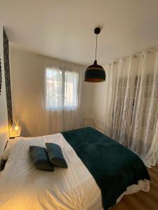 a bedroom with a large bed with two pillows on it at Appartement à 300 m du lac et des commerces in Annecy