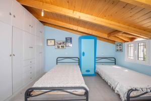 2 letti in una camera con pareti blu e soffitti in legno di Hillside hideaway a Skiadas