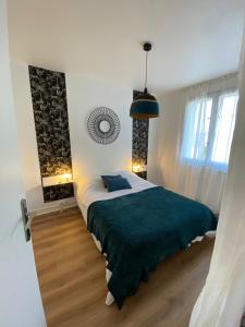 una camera da letto con un letto grande con una coperta verde di Appartement à 300 m du lac et des commerces ad Annecy