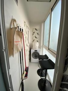 a laundry room with a washing machine and a chair at Appartement à 300 m du lac et des commerces in Annecy