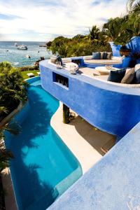 a blue house with a swimming pool next to the ocean at Casa Azul & Casa Carioca in Careyes in Careyes