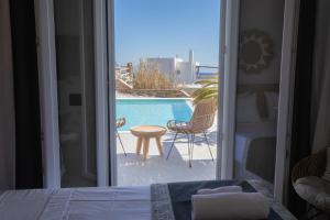 1 dormitorio con vistas a la piscina y 1 cama en SeaCode Villas, en Platis Gialos