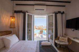 a bedroom with a bed and a view of a patio at SeaCode Villas in Platis Gialos
