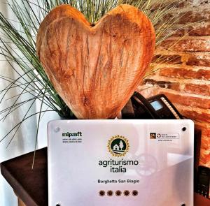 a wooden heart sitting on top of a laptop at Borghetto San Biagio Relais Agriturismo in Thiene