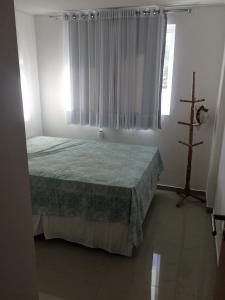 Schlafzimmer mit einem Bett und einem Fenster in der Unterkunft Alugo Apartamento para Contrato ANUAL, praia do Bessa, 2 quartos in João Pessoa