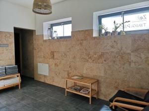 um quarto com uma parede de tijolos com uma mesa e uma janela em Zeit Hotel em Līgatne