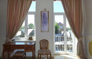 uma sala de jantar com uma mesa e duas janelas em Beautiful apartment in the center of Vinnytsia em Vinnytsya